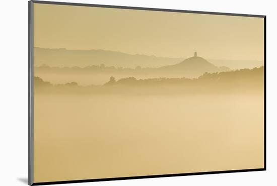 Glastonbury Tor and surrounding hills rising above early morning mist, Glastonbury, Somerset-Stuart Black-Mounted Photographic Print