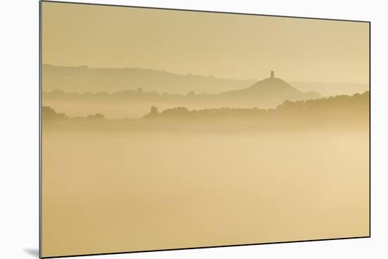 Glastonbury Tor and surrounding hills rising above early morning mist, Glastonbury, Somerset-Stuart Black-Mounted Photographic Print