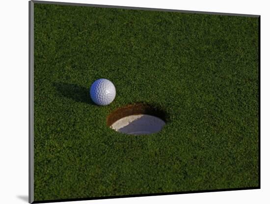 Golf Ball Sitting Near the Hole-null-Mounted Photographic Print