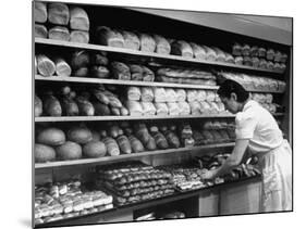 Good of Worker in Bakery Standing in Front of Shelves of Various Kinds of Breads and Rolls-Alfred Eisenstaedt-Mounted Photographic Print