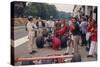 Graham Hill Watches Mechanics Working on a Car, French Grand Prix, Rouen, 1968-null-Stretched Canvas