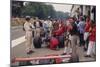 Graham Hill Watches Mechanics Working on a Car, French Grand Prix, Rouen, 1968-null-Mounted Photographic Print