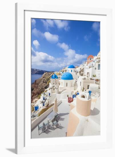 Greek Church with Three Blue Domes in the Village of Oia-Neale Clark-Framed Photographic Print