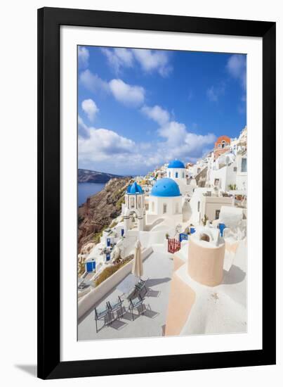 Greek Church with Three Blue Domes in the Village of Oia-Neale Clark-Framed Photographic Print