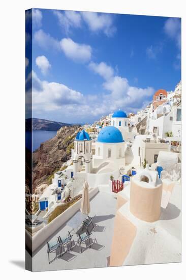 Greek Church with Three Blue Domes in the Village of Oia-Neale Clark-Stretched Canvas