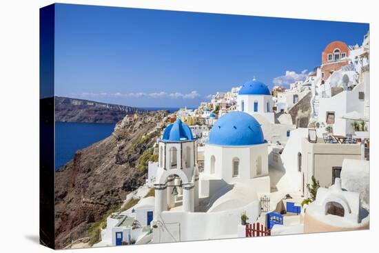 Greek Church with Three Blue Domes in the Village of Oia-Neale Clark-Stretched Canvas