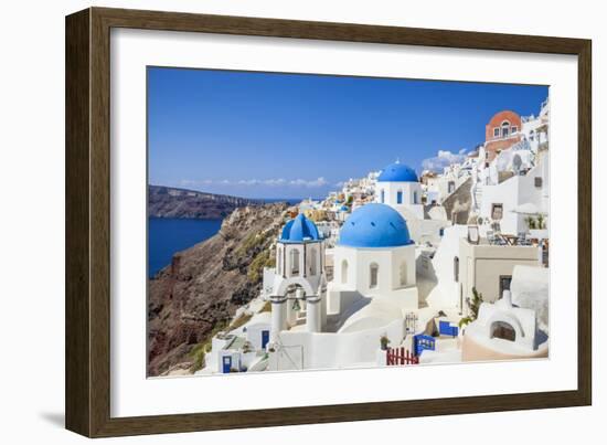 Greek Church with Three Blue Domes in the Village of Oia-Neale Clark-Framed Photographic Print