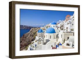 Greek Church with Three Blue Domes in the Village of Oia-Neale Clark-Framed Photographic Print