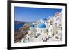 Greek Church with Three Blue Domes in the Village of Oia-Neale Clark-Framed Photographic Print