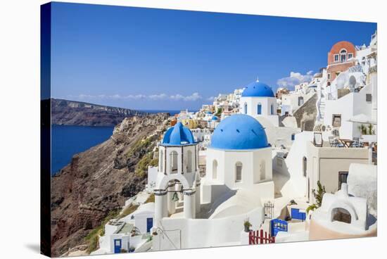 Greek Church with Three Blue Domes in the Village of Oia-Neale Clark-Stretched Canvas