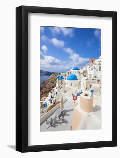 Greek Church with Three Blue Domes in the Village of Oia-Neale Clark-Framed Photographic Print