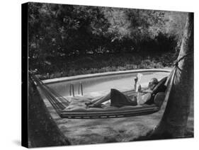 Greer Garson Reading While Relaxing in a Hammock Near Her Pool at Home-Peter Stackpole-Stretched Canvas