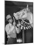 Groom Cleaning Horse's Teeth During Filming of the Movie "The Ziegfeld Follies"-John Florea-Mounted Photographic Print