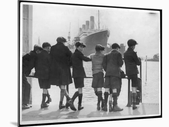 Group of Boys Lean Against the Dock Railings and Watch a Steamship Being Built-null-Mounted Art Print