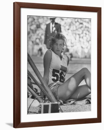 Gunhild Larking, Sweden's Entry for High Jump, Nervously Awaiting Turn to Compete at Olympic Games-George Silk-Framed Premium Photographic Print