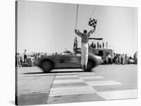 Man jumping waving checkered flag-H^ Armstrong Roberts-Stretched Canvas