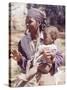 Haitian Woman Smoking a Pipe while Holding a Baby-Lynn Pelham-Stretched Canvas