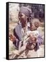 Haitian Woman Smoking a Pipe while Holding a Baby-Lynn Pelham-Framed Stretched Canvas