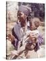 Haitian Woman Smoking a Pipe while Holding a Baby-Lynn Pelham-Stretched Canvas