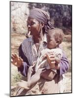 Haitian Woman Smoking a Pipe while Holding a Baby-Lynn Pelham-Mounted Photographic Print