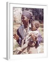 Haitian Woman Smoking a Pipe while Holding a Baby-Lynn Pelham-Framed Photographic Print