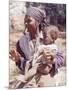 Haitian Woman Smoking a Pipe while Holding a Baby-Lynn Pelham-Mounted Photographic Print