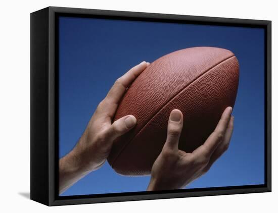 Hands Holding Football with Blue Background-null-Framed Stretched Canvas