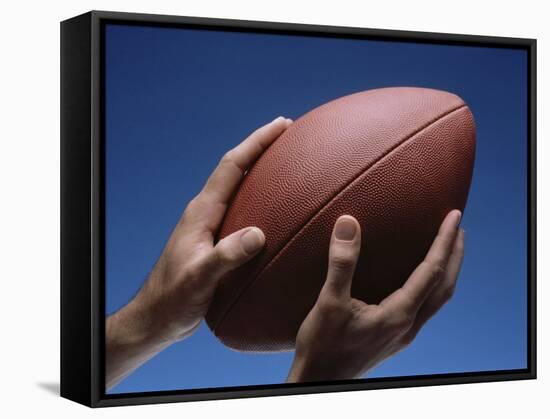 Hands Holding Football with Blue Background-null-Framed Stretched Canvas