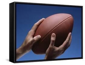 Hands Holding Football with Blue Background-null-Framed Stretched Canvas