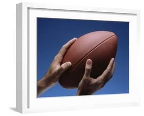 Hands Holding Football with Blue Background-null-Framed Photographic Print