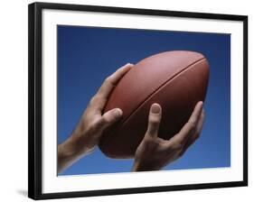 Hands Holding Football with Blue Background-null-Framed Photographic Print