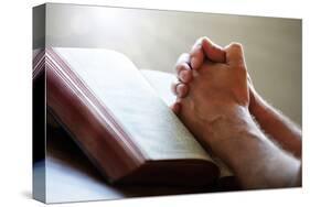 Hands Praying on a Holy Bible-null-Stretched Canvas