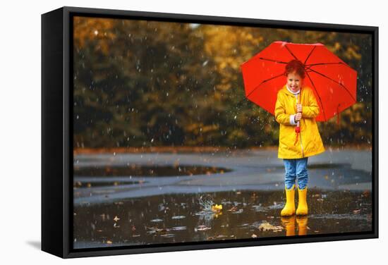 Happy Child Girl with an Umbrella and Rubber Boots in Puddle on an Autumn Walk-null-Framed Stretched Canvas