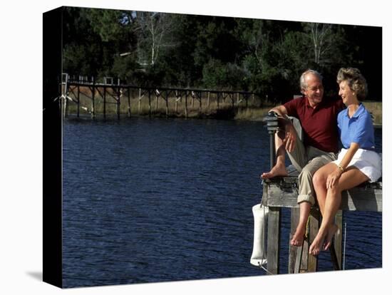 Healthy Couple Sitting on the Dock by a Lake-Bill Bachmann-Stretched Canvas