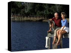 Healthy Couple Sitting on the Dock by a Lake-Bill Bachmann-Stretched Canvas