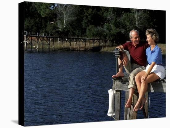 Healthy Couple Sitting on the Dock by a Lake-Bill Bachmann-Stretched Canvas