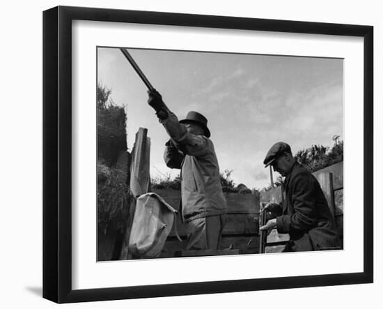 Herbert Lee Pratt Firing His Gun Toward a Grouse While the Loader Reloads Ammunition-John Phillips-Framed Photographic Print