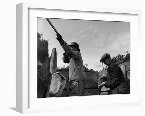 Herbert Lee Pratt Firing His Gun Toward a Grouse While the Loader Reloads Ammunition-John Phillips-Framed Photographic Print