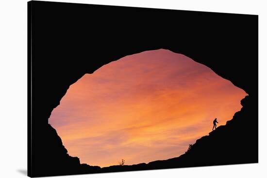Hiker Climbing a Natural Arch in Utah-null-Stretched Canvas