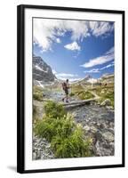 Hiker crossing a stream Engadine Canton of Grisons Switzerland Europe-ClickAlps-Framed Photographic Print