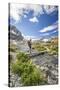 Hiker crossing a stream Engadine Canton of Grisons Switzerland Europe-ClickAlps-Stretched Canvas