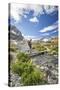 Hiker crossing a stream Engadine Canton of Grisons Switzerland Europe-ClickAlps-Stretched Canvas