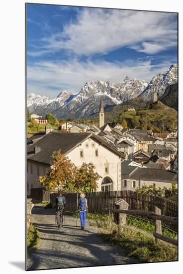 Hikers admire Ardez village surrounded by woods and snowy peaks Lower Engadine Canton of Switzerlan-ClickAlps-Mounted Photographic Print