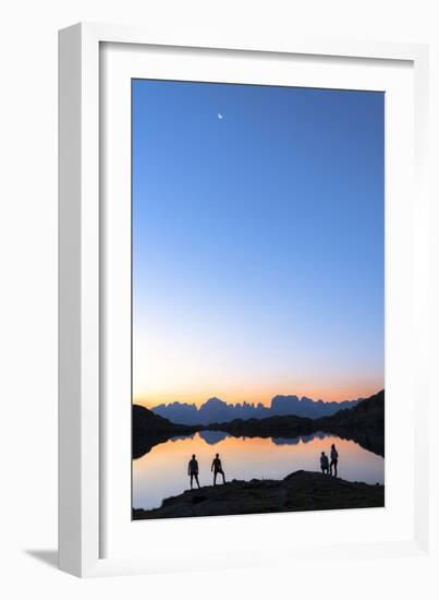 Hikers admiring Brenta Group Dolomites reflected in Lago Nero di Cornisello at dawn-Roberto Moiola-Framed Photographic Print