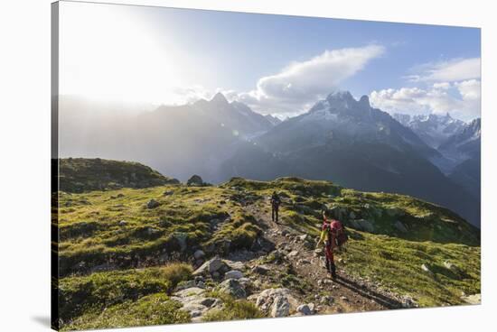 Hikers on the way to Lacs De Cheserys from Argentiere with Les Drus and Aiguille Verte in the backg-Roberto Moiola-Stretched Canvas