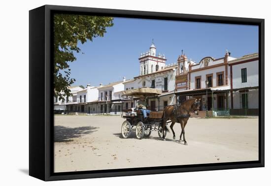 Horse and carriage riding along sand streets with brotherhood houses behind, El Rocio, Huelva Provi-Stuart Black-Framed Stretched Canvas