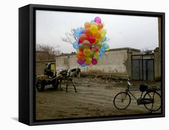 Horse Drawn Cart Drives Past as Balloons Tied to a Bicycle Flutter in the Wind-null-Framed Stretched Canvas