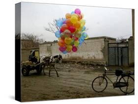 Horse Drawn Cart Drives Past as Balloons Tied to a Bicycle Flutter in the Wind-null-Stretched Canvas