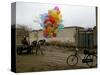 Horse Drawn Cart Drives Past as Balloons Tied to a Bicycle Flutter in the Wind-null-Stretched Canvas