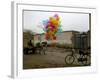 Horse Drawn Cart Drives Past as Balloons Tied to a Bicycle Flutter in the Wind-null-Framed Photographic Print